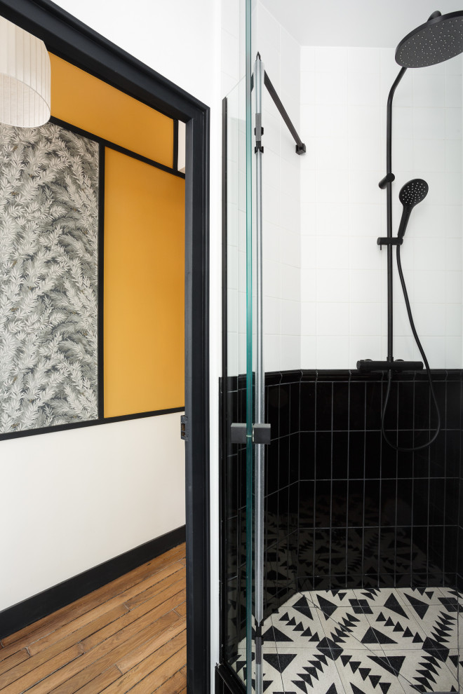 Small midcentury master bathroom in Paris with flat-panel cabinets, white cabinets, an alcove shower, a wall-mount toilet, black and white tile, ceramic tile, white walls, cement tiles, a drop-in sink, tile benchtops, black floor, a hinged shower door, black benchtops, a single vanity and a floating vanity.