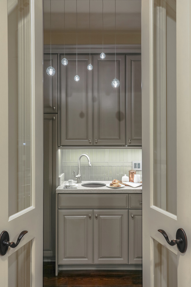 Small contemporary kitchen pantry in New Orleans with an undermount sink, raised-panel cabinets, grey cabinets, quartzite benchtops, glass tile splashback, stainless steel appliances, dark hardwood floors, no island and white benchtop.