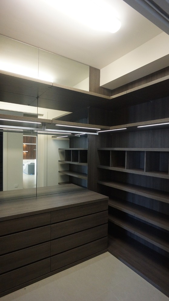 This is an example of a mid-sized modern women's walk-in wardrobe in Miami with flat-panel cabinets, dark wood cabinets and porcelain floors.