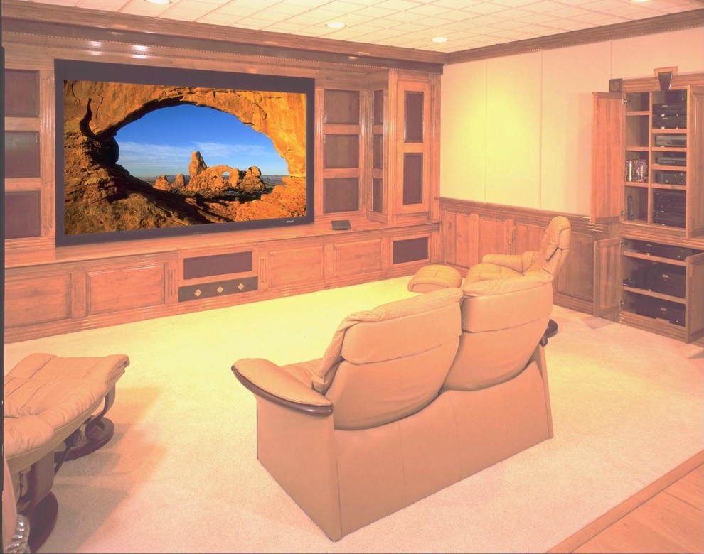 Inspiration for a mid-sized traditional open concept home theatre in Other with beige walls, carpet and a built-in media wall.