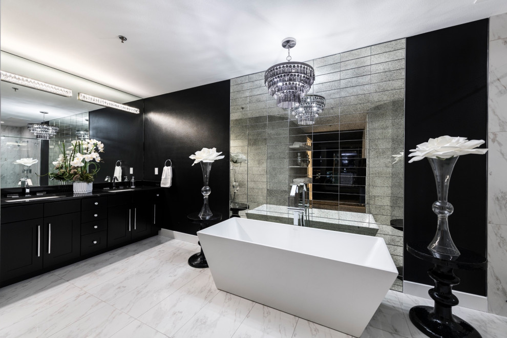Photo of a large contemporary kids bathroom in Las Vegas with flat-panel cabinets, black cabinets, a freestanding tub, an open shower, a one-piece toilet, gray tile, ceramic tile, white walls, ceramic floors, an undermount sink, marble benchtops, a hinged shower door, black benchtops, a double vanity and a floating vanity.