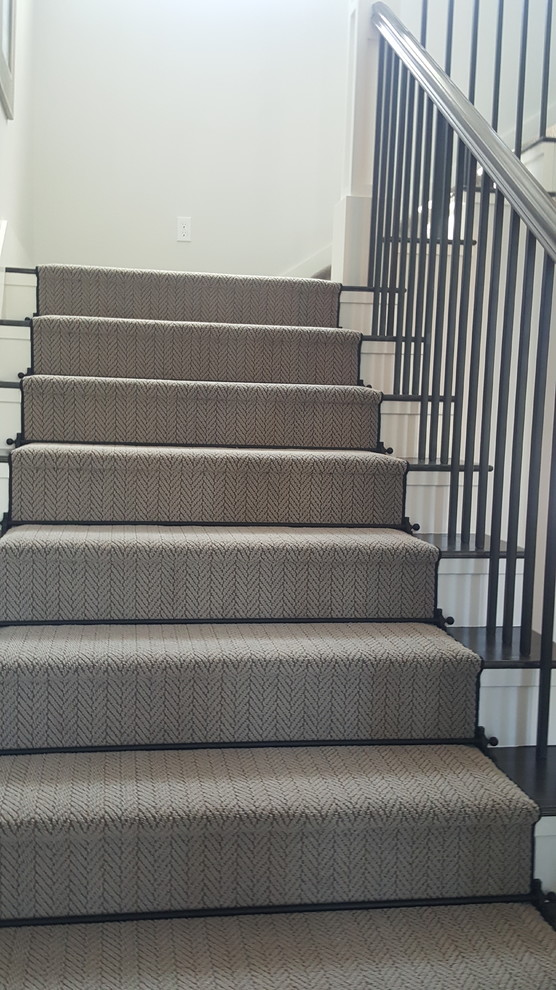 This is an example of a small traditional carpeted u-shaped staircase in Other with carpet risers and mixed railing.