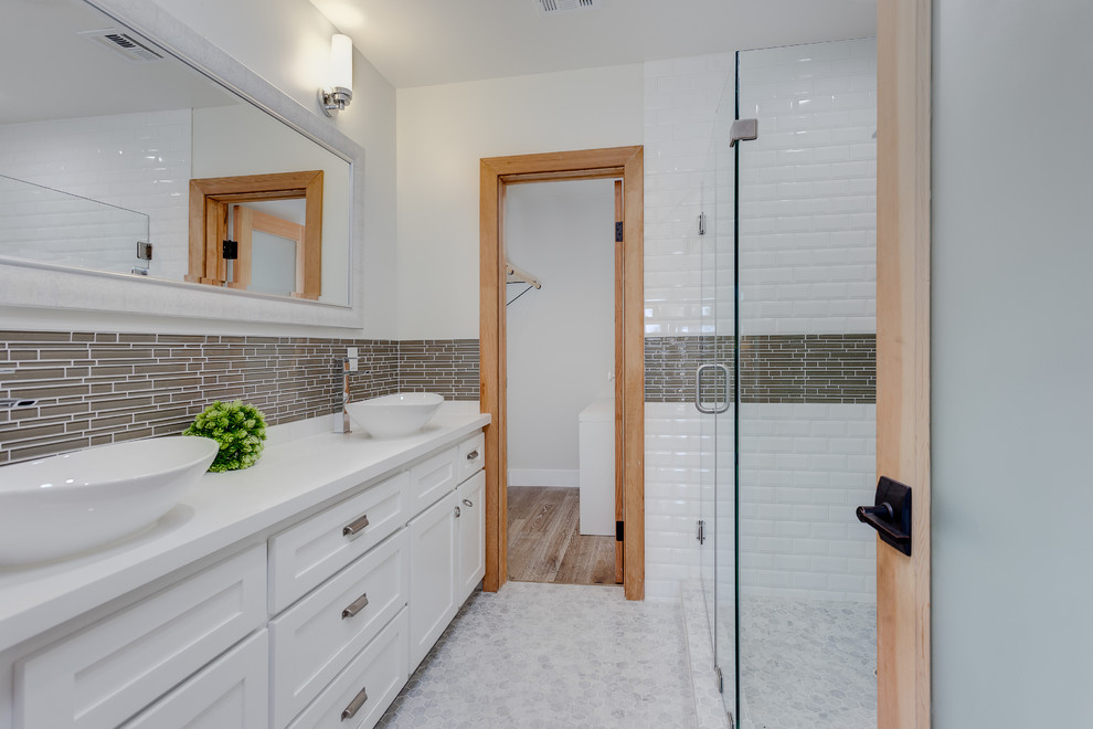 Design ideas for a mid-sized country 3/4 bathroom in Los Angeles with a vessel sink, shaker cabinets, white cabinets, a curbless shower, brown tile, white tile, subway tile, white walls, granite benchtops, mosaic tile floors, grey floor, a hinged shower door and white benchtops.