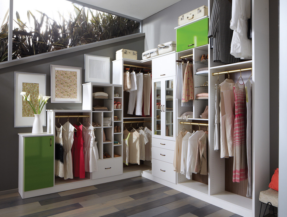 This is an example of a mid-sized contemporary women's walk-in wardrobe in Nashville with open cabinets, white cabinets and dark hardwood floors.