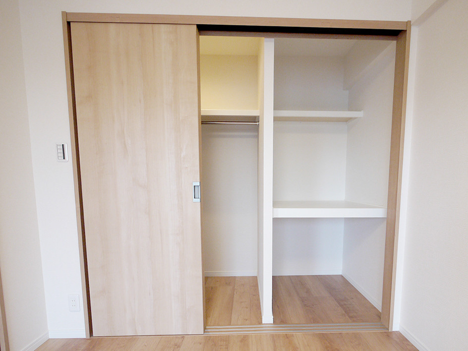 This is an example of a scandinavian walk-in wardrobe in Tokyo with light wood cabinets, light hardwood floors and beige floor.
