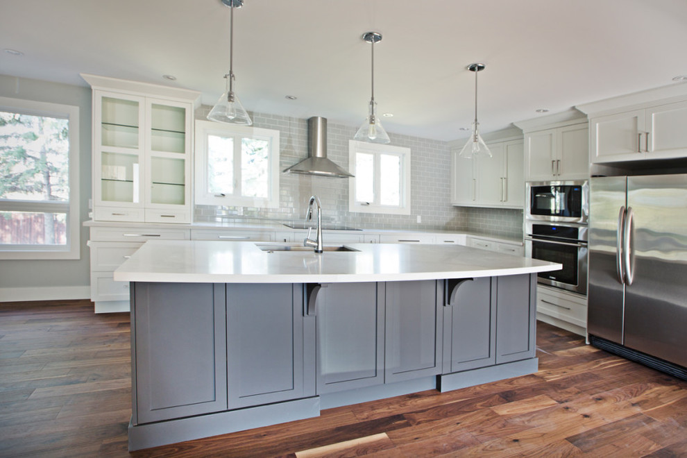 Eat-in kitchen - large transitional l-shaped dark wood floor eat-in kitchen idea in Calgary with an undermount sink, recessed-panel cabinets, white cabinets, gray backsplash, subway tile backsplash, stainless steel appliances, an island and quartz countertops