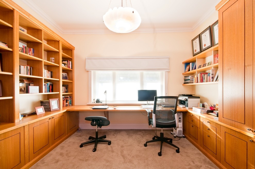 Photo of an expansive transitional study room in Melbourne with a built-in desk, white walls, carpet and no fireplace.