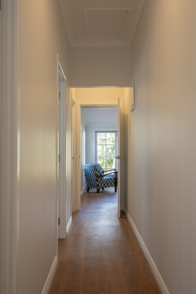 Immagine di un grande ingresso o corridoio tradizionale con pareti bianche, moquette, pavimento marrone e soffitto a cassettoni