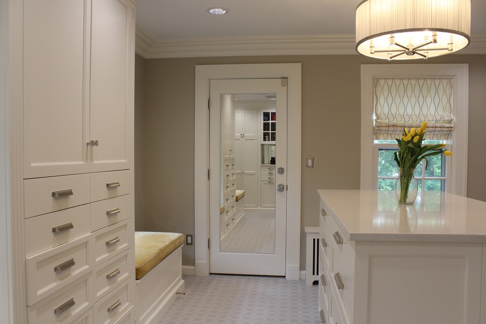 Photo of a transitional women's dressing room in New York with flat-panel cabinets, white cabinets and carpet.