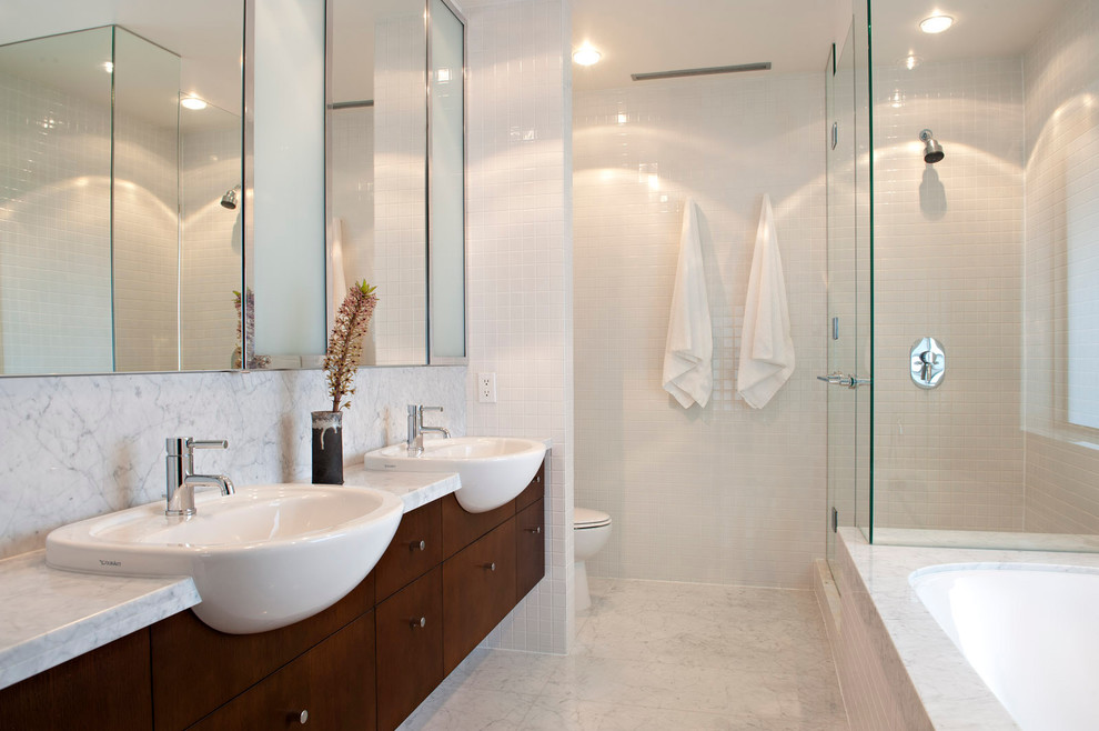 This is an example of a modern bathroom in Vancouver with a drop-in sink, flat-panel cabinets, dark wood cabinets, an undermount tub, a corner shower, white tile and mosaic tile.