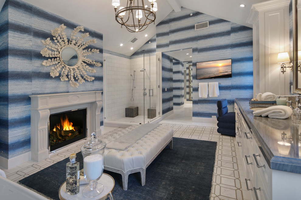 Design ideas for a beach style master bathroom in Orange County with recessed-panel cabinets, white cabinets, a corner shower, white tile, blue walls, an undermount sink, grey floor, a hinged shower door and blue benchtops.