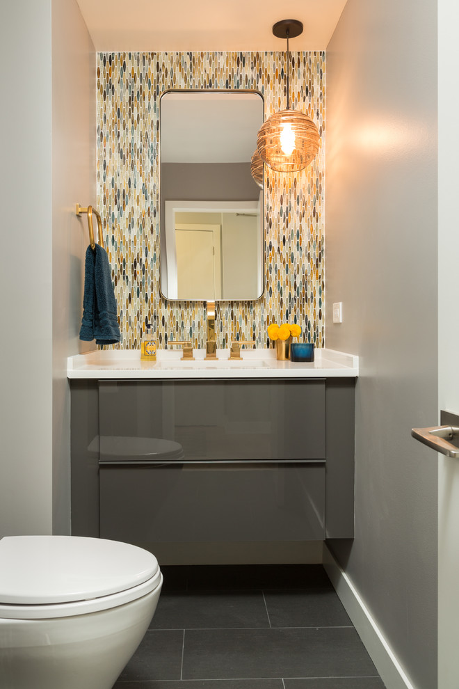 Photo of a small contemporary powder room in Chicago with flat-panel cabinets, grey cabinets, multi-coloured tile, glass tile, grey walls, porcelain floors, an undermount sink and engineered quartz benchtops.