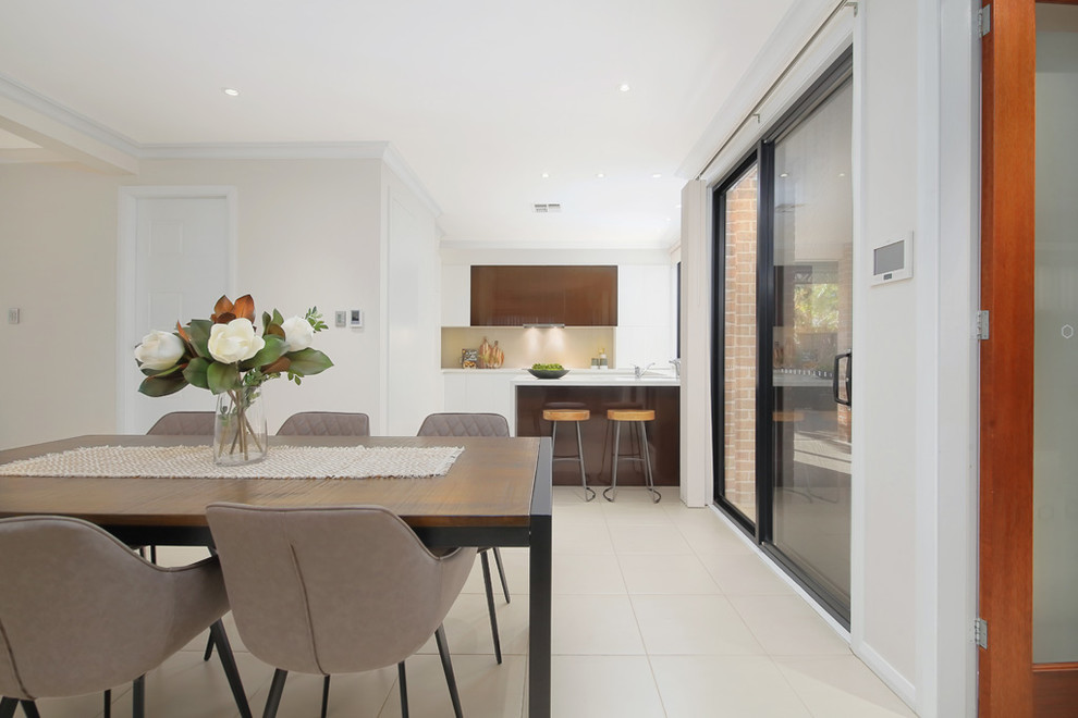 This is an example of a large contemporary open plan dining in Sydney with white walls, ceramic floors and beige floor.