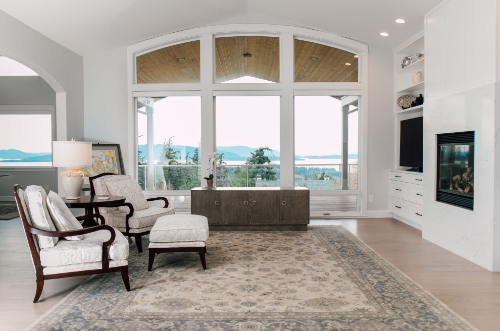 Inspiration for an expansive contemporary formal open concept living room in Seattle with grey walls, light hardwood floors, a standard fireplace, a wall-mounted tv, beige floor and vaulted.