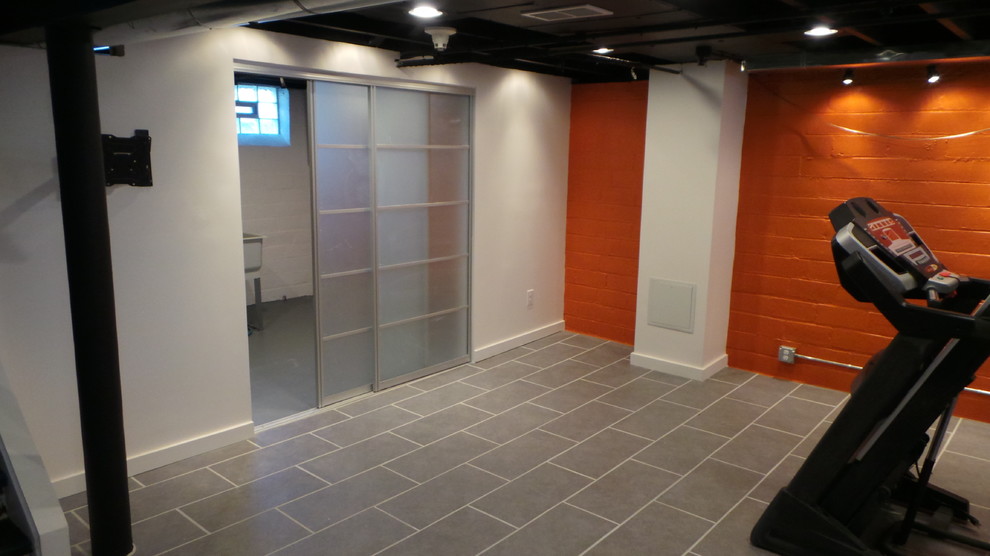 Mid-sized contemporary look-out basement in Cleveland with orange walls, porcelain floors and no fireplace.