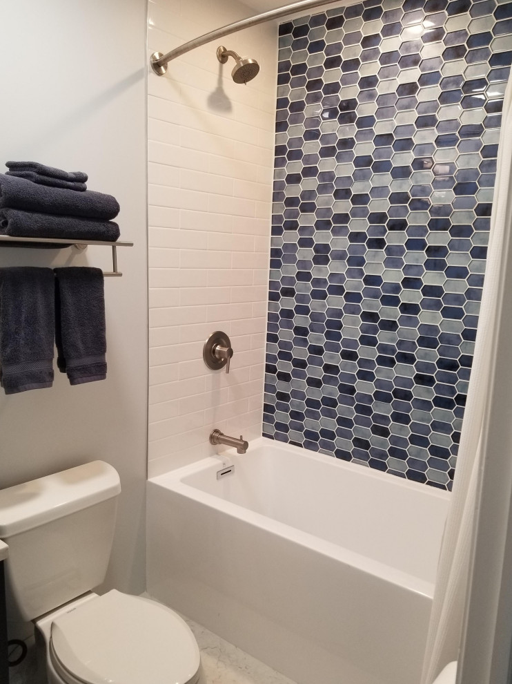 Inredning av ett klassiskt litet vit vitt badrum, med blå skåp, ett badkar i en alkov, en dusch/badkar-kombination, blå kakel, glasskiva, klinkergolv i porslin, bänkskiva i kvarts och grått golv