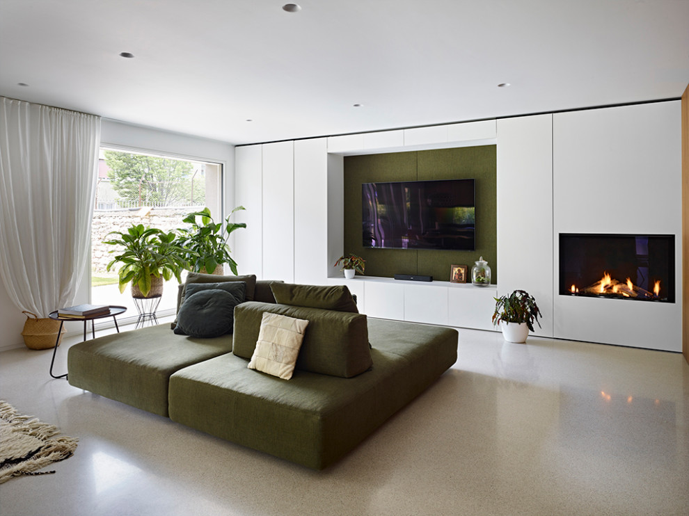 Inspiration for a contemporary open concept living room in Other with a standard fireplace, a plaster fireplace surround, a wall-mounted tv, grey floor and wood walls.