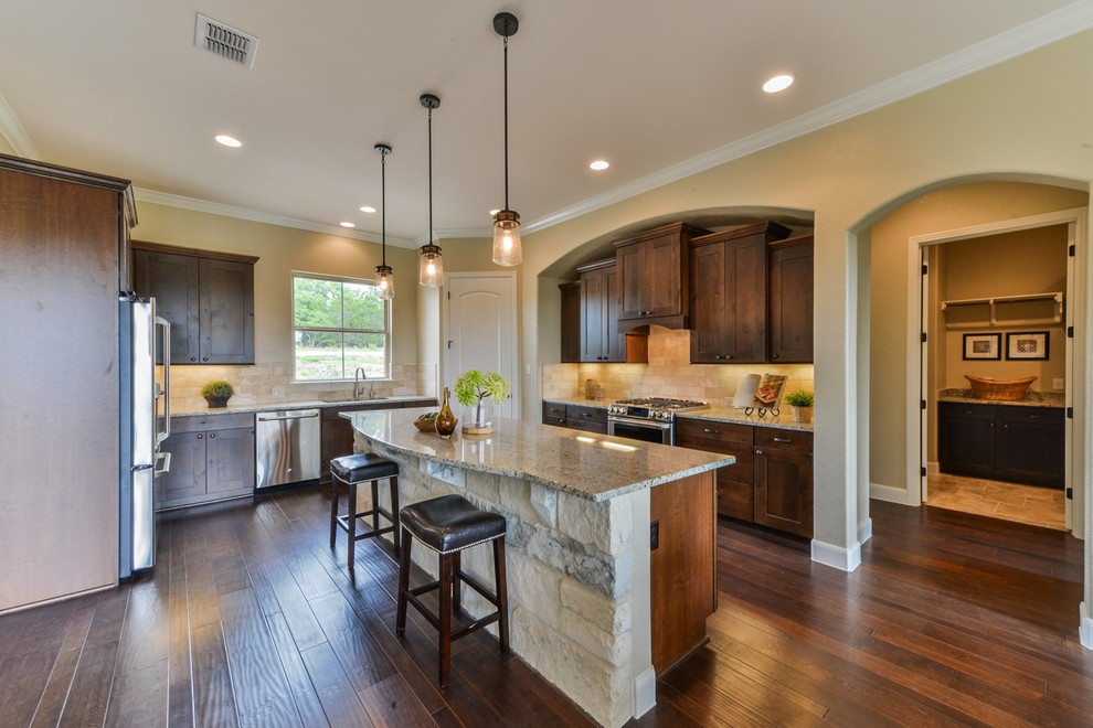 Kitchen - large rustic u-shaped medium tone wood floor and brown floor kitchen idea in Austin with an undermount sink, shaker cabinets, medium tone wood cabinets, granite countertops, brown backsplash, subway tile backsplash, stainless steel appliances and an island