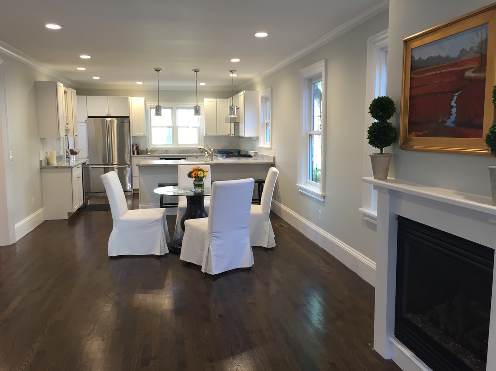 Inspiration for a mid-sized transitional medium tone wood floor kitchen/dining room combo remodel in Boston with white walls, a standard fireplace and a wood fireplace surround