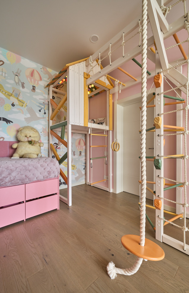 Inspiration pour une chambre d'enfant de 4 à 10 ans design de taille moyenne avec un mur rose, un sol en bois brun, un sol beige et du papier peint.
