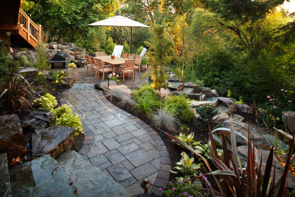 Design ideas for a large traditional backyard patio in Seattle with natural stone pavers and no cover.