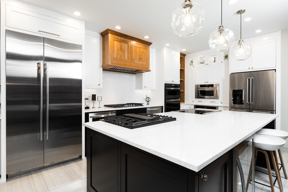 Mid-sized transitional l-shaped porcelain tile and beige floor enclosed kitchen photo in Albuquerque with shaker cabinets, white cabinets, quartz countertops, white backsplash, mosaic tile backsplash, stainless steel appliances, an island and white countertops