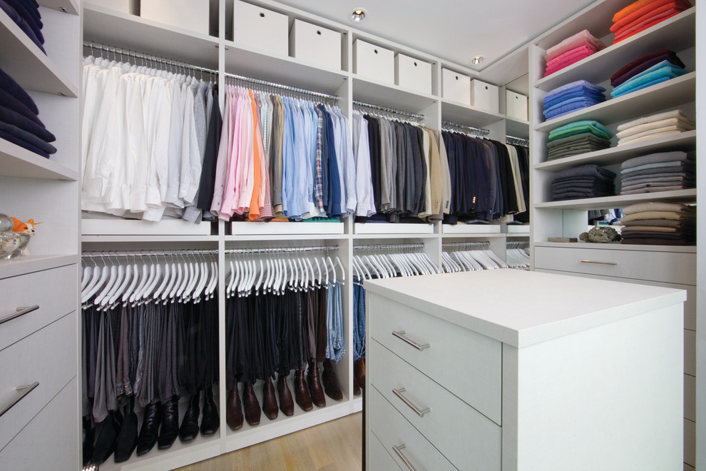 Inspiration for a large transitional gender-neutral walk-in wardrobe in Austin with flat-panel cabinets, white cabinets and light hardwood floors.