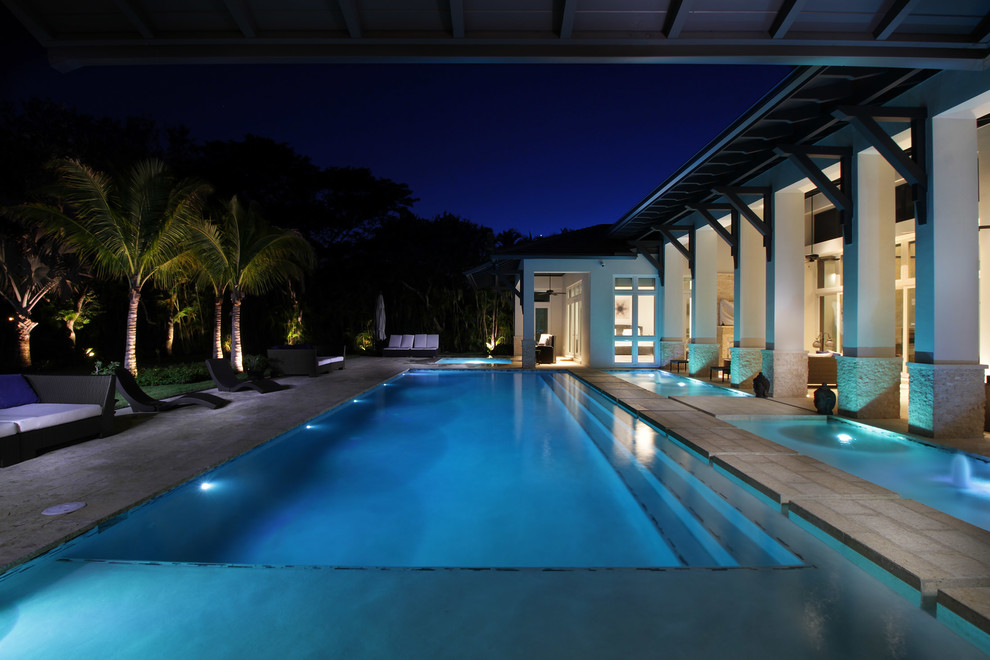 Design ideas for a large transitional backyard rectangular pool in Miami with concrete pavers.