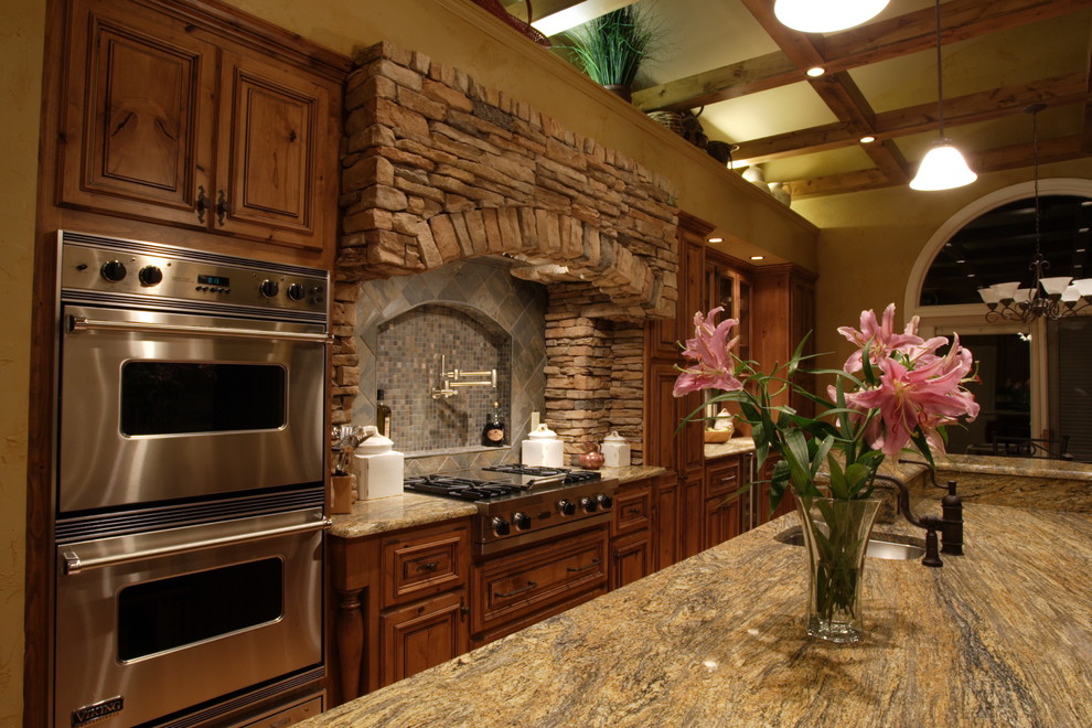 Example of a mountain style eat-in kitchen design in St Louis with an undermount sink, raised-panel cabinets, medium tone wood cabinets, granite countertops and stainless steel appliances