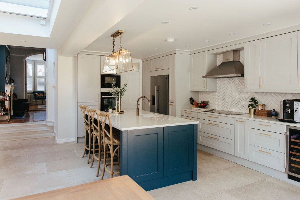 Open concept kitchen - large traditional limestone floor and gray floor open concept kitchen idea in Surrey with shaker cabinets, porcelain backsplash, an island and white countertops