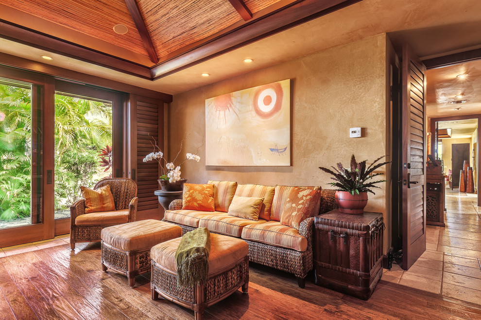 Photo of a large tropical study room in Hawaii with beige walls, medium hardwood floors and a built-in desk.