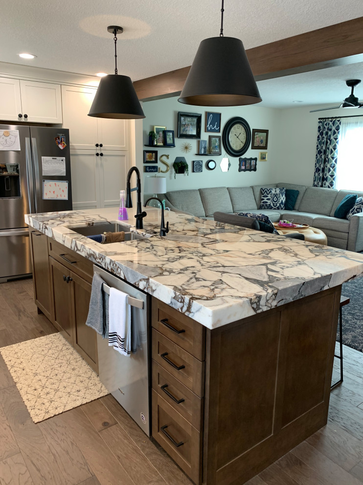 Open concept kitchen - large transitional l-shaped open concept kitchen idea with an undermount sink, shaker cabinets, white cabinets, stainless steel appliances and an island