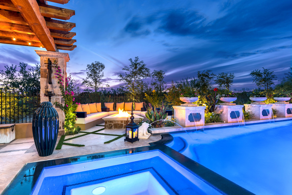 Expansive traditional backyard custom-shaped lap pool in Phoenix with a hot tub and natural stone pavers.
