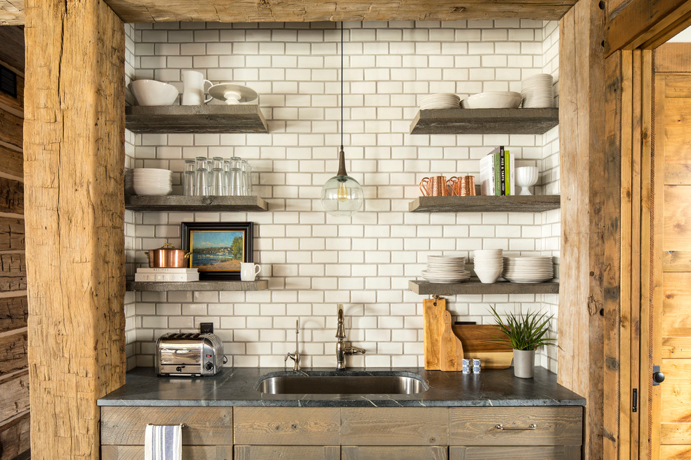 Eat-in kitchen - large rustic u-shaped dark wood floor and brown floor eat-in kitchen idea in Minneapolis with an undermount sink, shaker cabinets, medium tone wood cabinets, soapstone countertops, white backsplash, ceramic backsplash, paneled appliances and an island