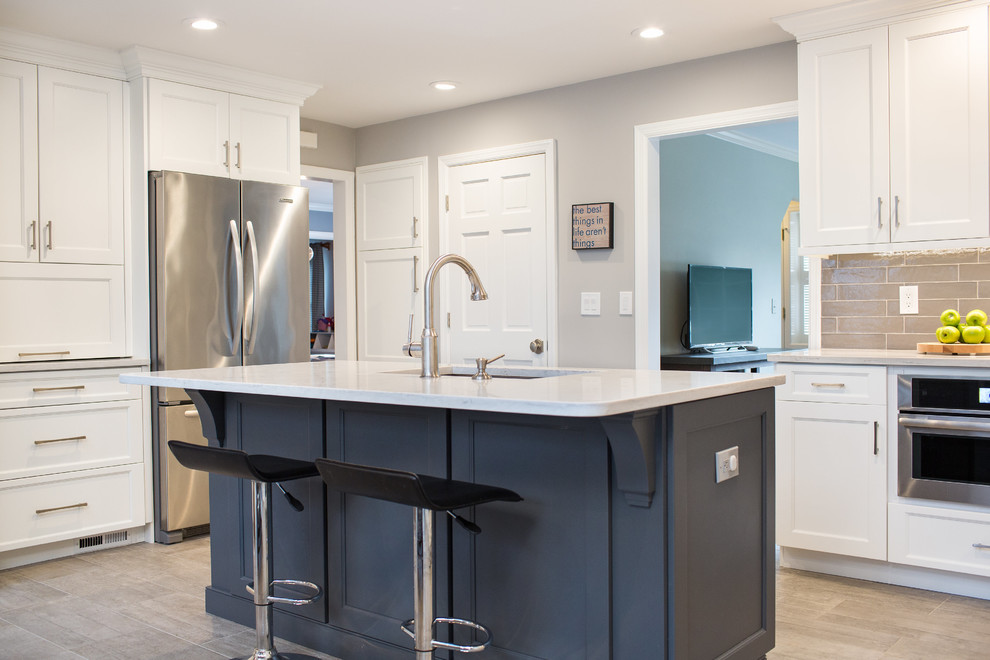Open concept kitchen - large transitional ceramic tile open concept kitchen idea in New York with an undermount sink, shaker cabinets, white cabinets, quartz countertops, gray backsplash, ceramic backsplash, stainless steel appliances and an island