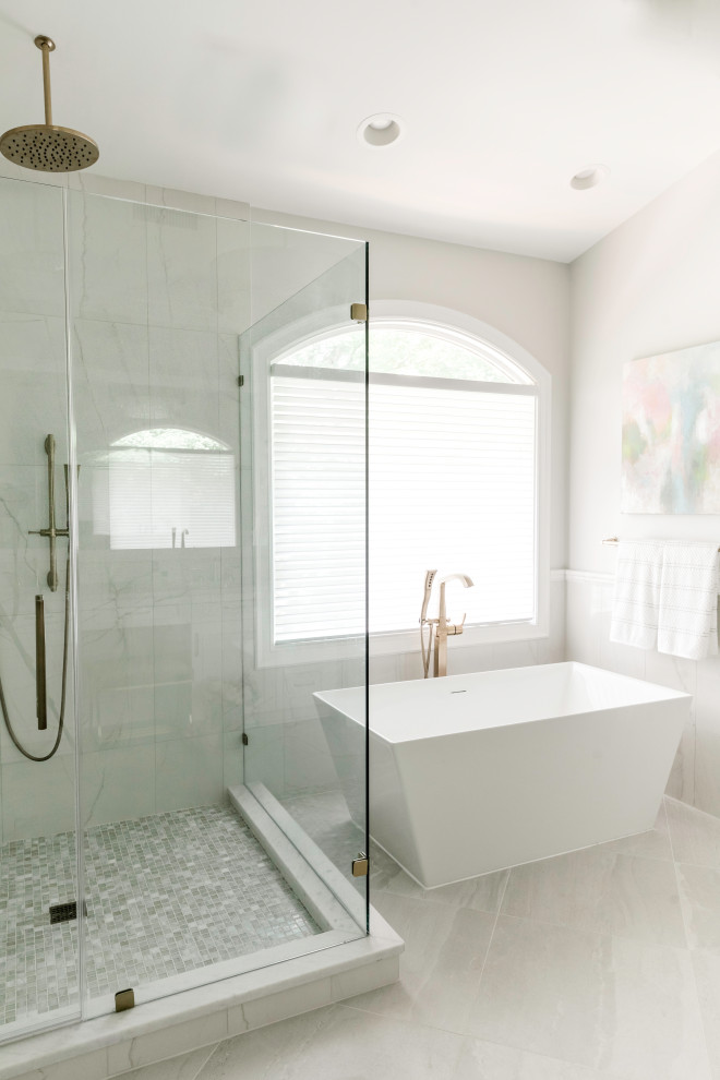 Example of a mid-sized transitional master white tile and marble tile porcelain tile, gray floor and double-sink freestanding bathtub design in Charlotte with recessed-panel cabinets, white cabinets, gray walls, an undermount sink, marble countertops, a hinged shower door, white countertops, a niche and a built-in vanity