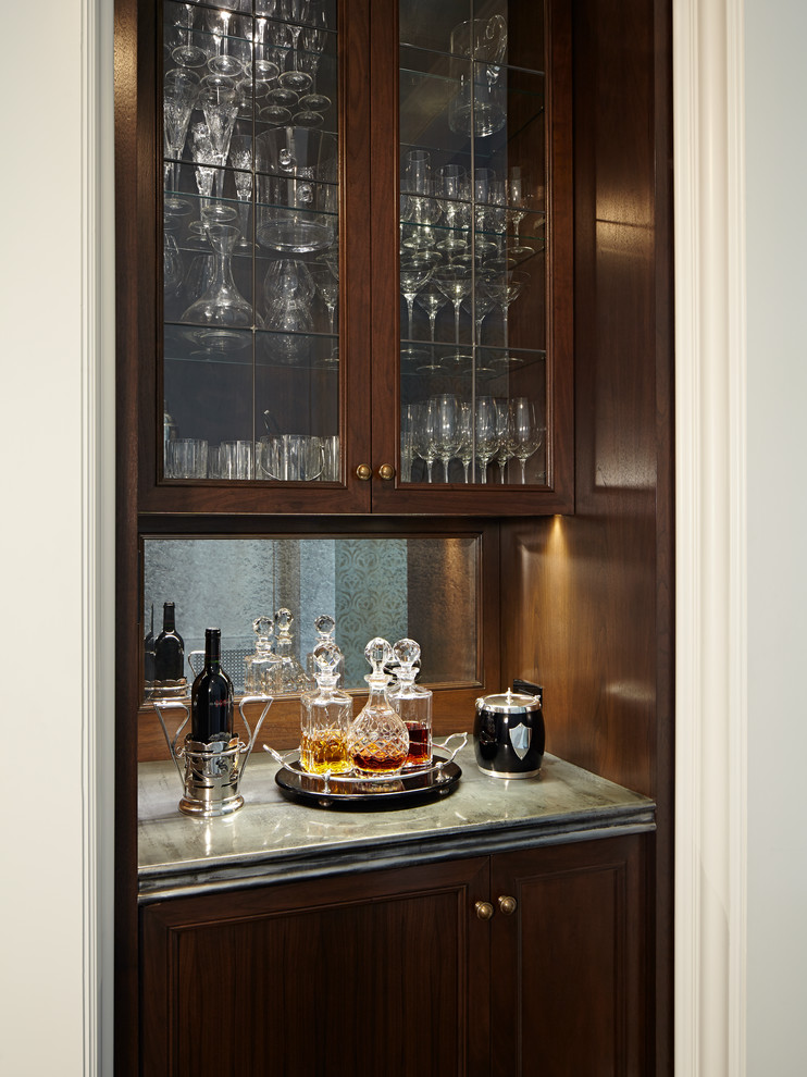 Design ideas for a small traditional single-wall wet bar in Chicago with no sink, recessed-panel cabinets, dark wood cabinets, marble benchtops and mirror splashback.