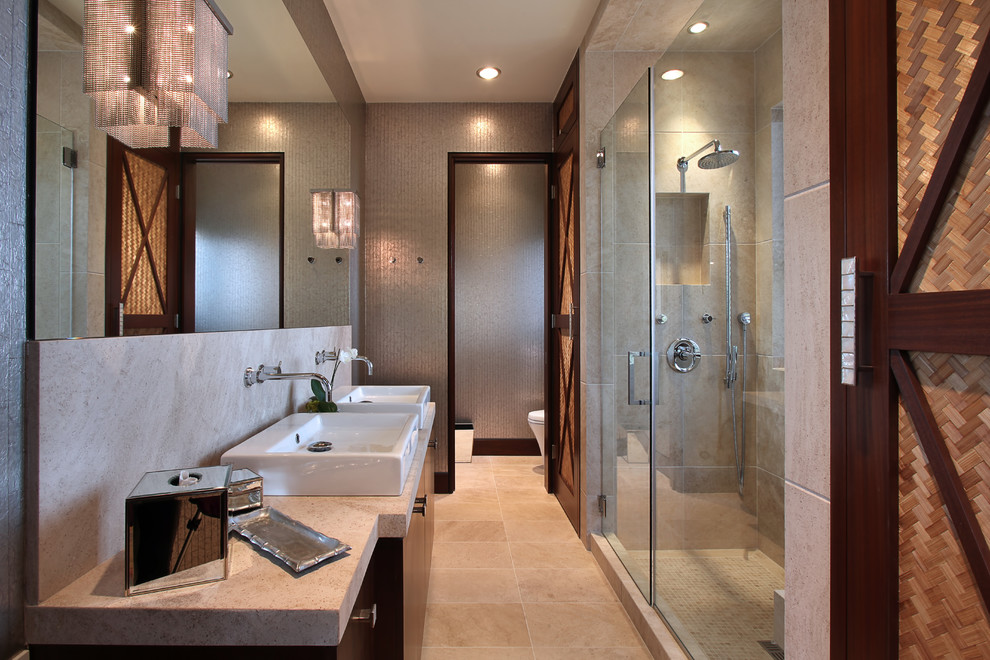 This is an example of a contemporary bathroom in Orange County with a vessel sink, flat-panel cabinets, dark wood cabinets, an alcove shower and beige tile.