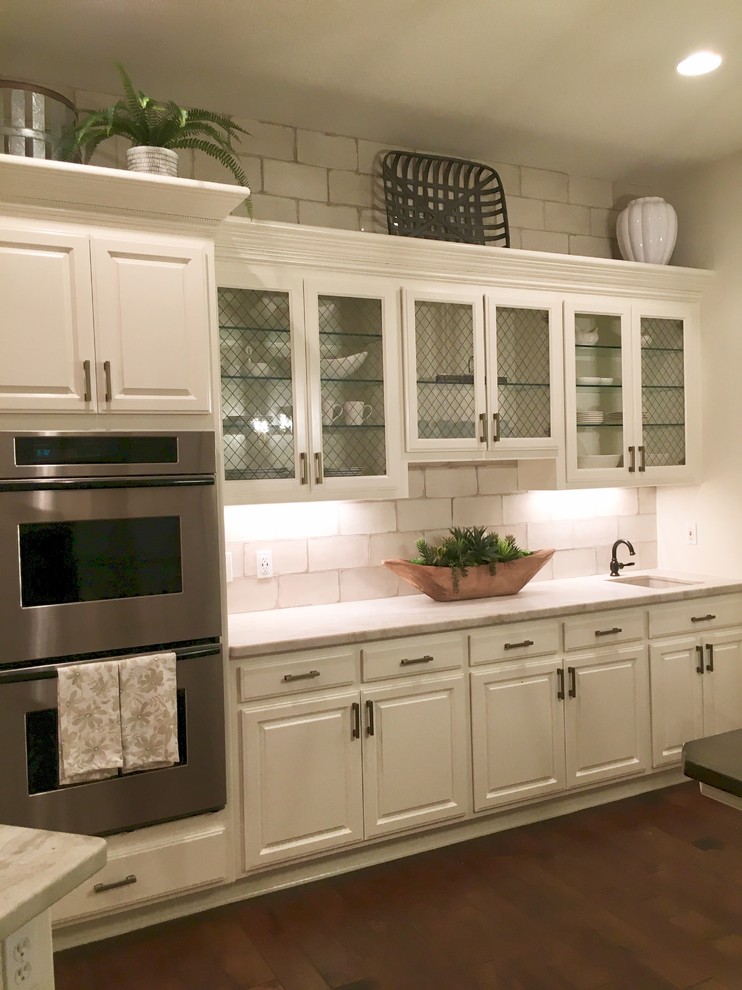 Aménagement d'une cuisine contemporaine avec un placard avec porte à panneau encastré et des portes de placard blanches.