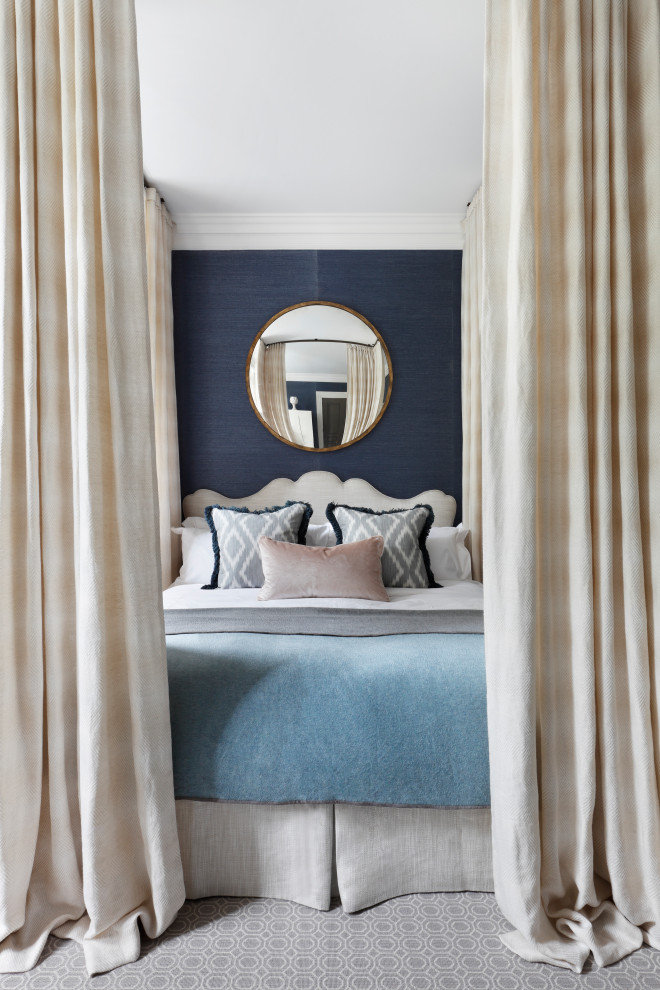 Photo of a large traditional master bedroom in London with blue walls, carpet and grey floor.