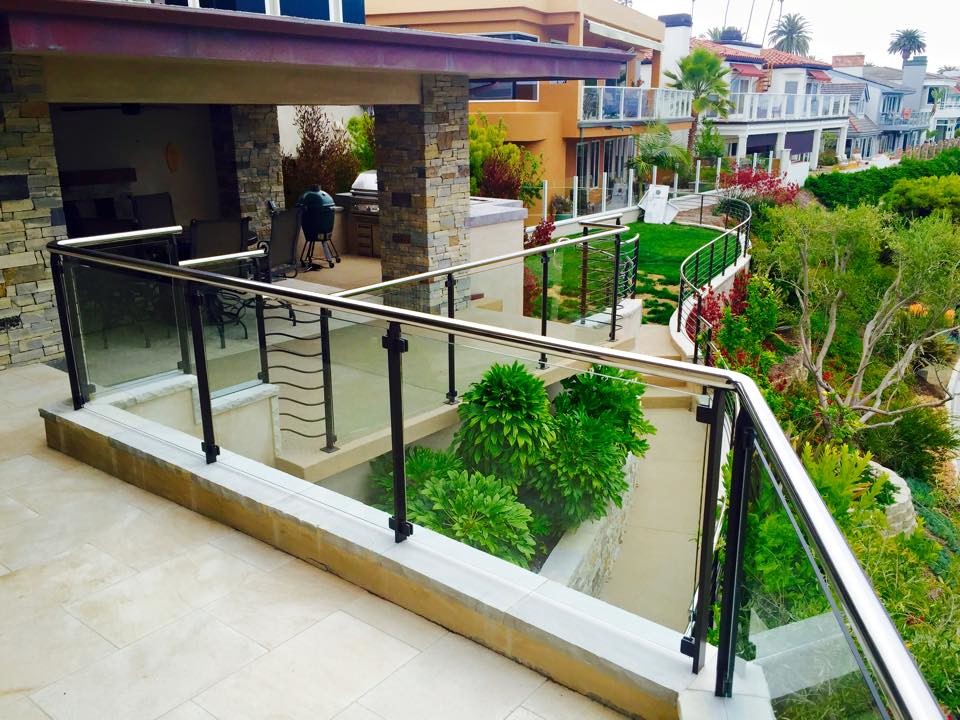 This is an example of a large modern front yard patio in Orange County with natural stone pavers and a roof extension.