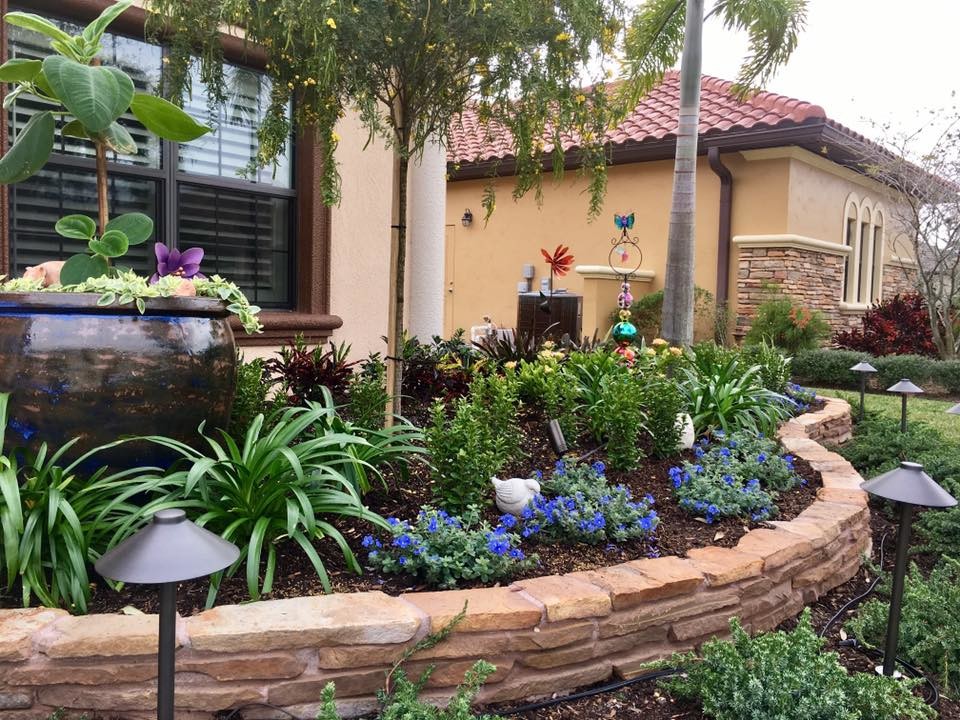 Design ideas for a mid-sized traditional front yard full sun garden for summer in Orlando with concrete pavers.