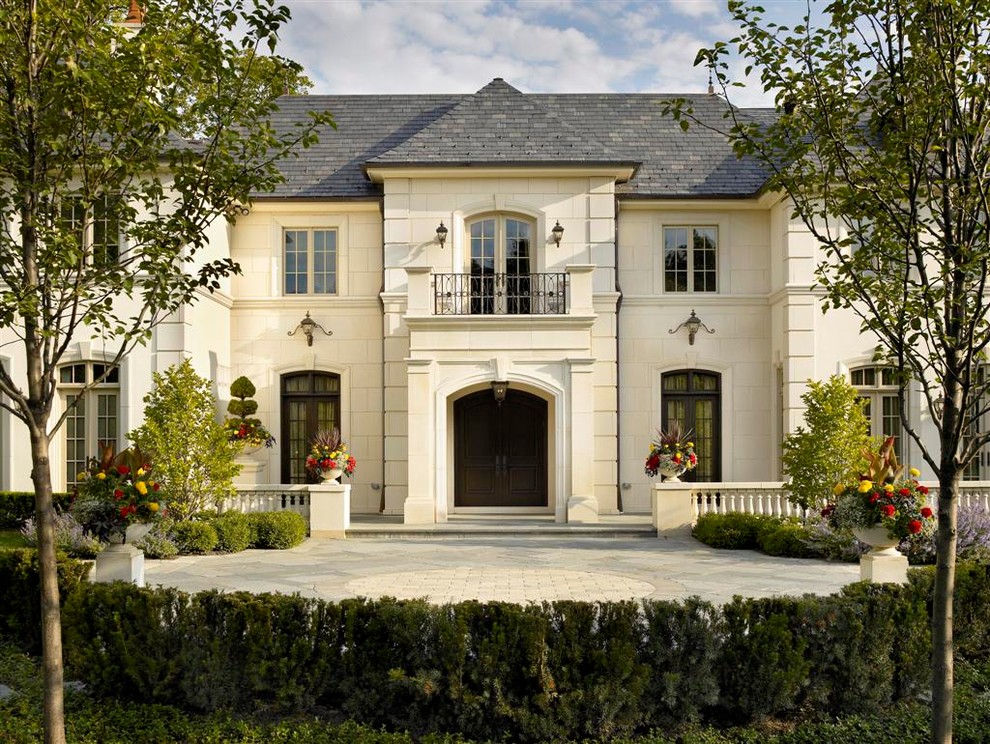 Design ideas for a large traditional two-storey beige exterior in Chicago with stone veneer.