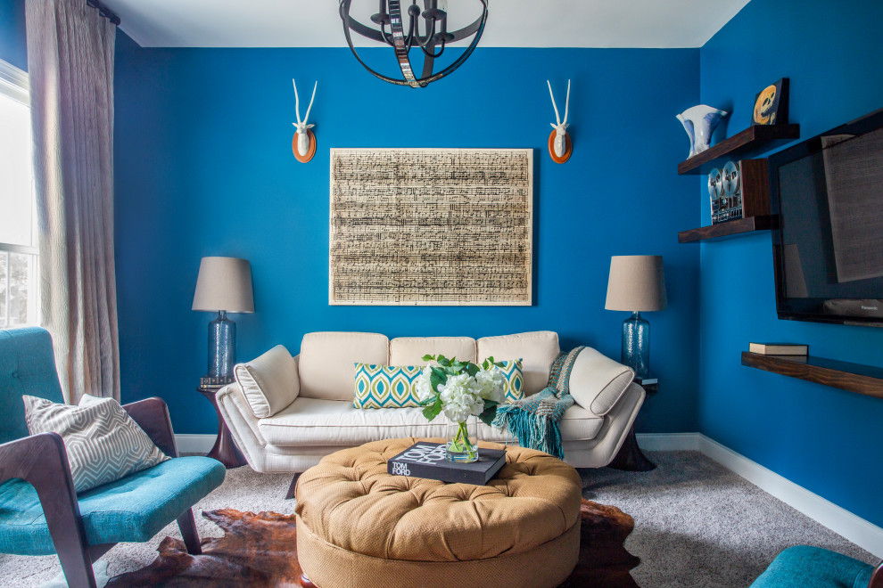 This is an example of a transitional enclosed living room in Raleigh with blue walls, carpet, a wall-mounted tv and grey floor.
