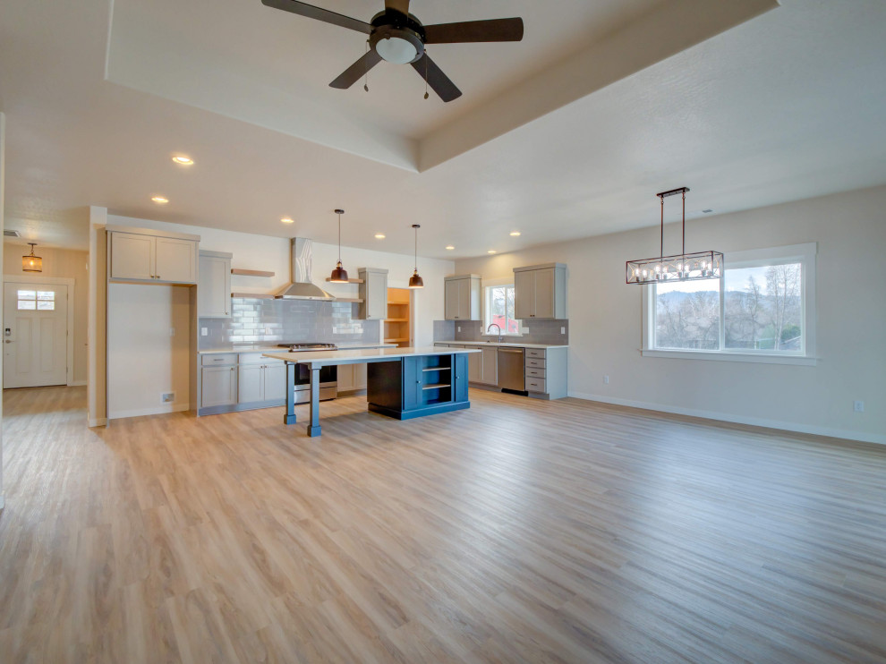 Example of a large transitional l-shaped laminate floor and beige floor eat-in kitchen design with an undermount sink, shaker cabinets, gray cabinets, quartz countertops, gray backsplash, ceramic backsplash, stainless steel appliances, an island and white countertops