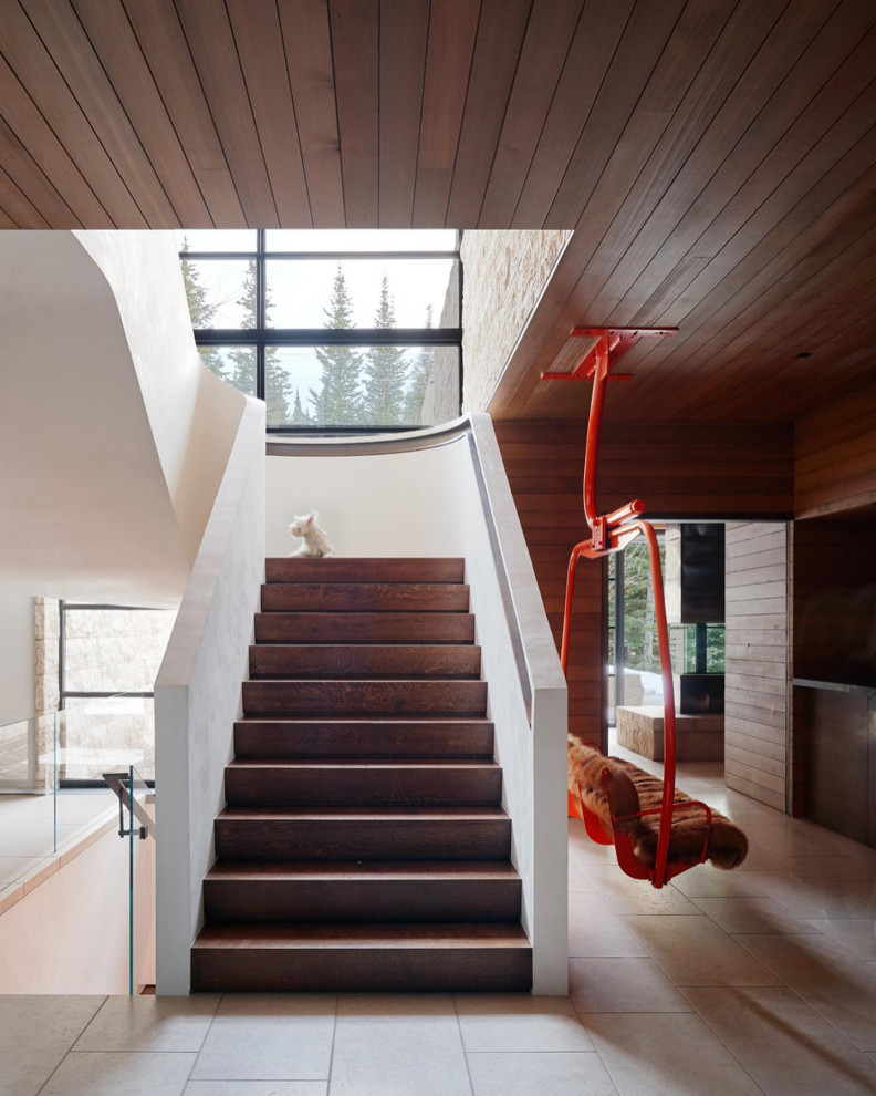 Inspiration pour un très grand escalier courbe minimaliste avec des marches en bois, des contremarches en bois et un garde-corps en bois.