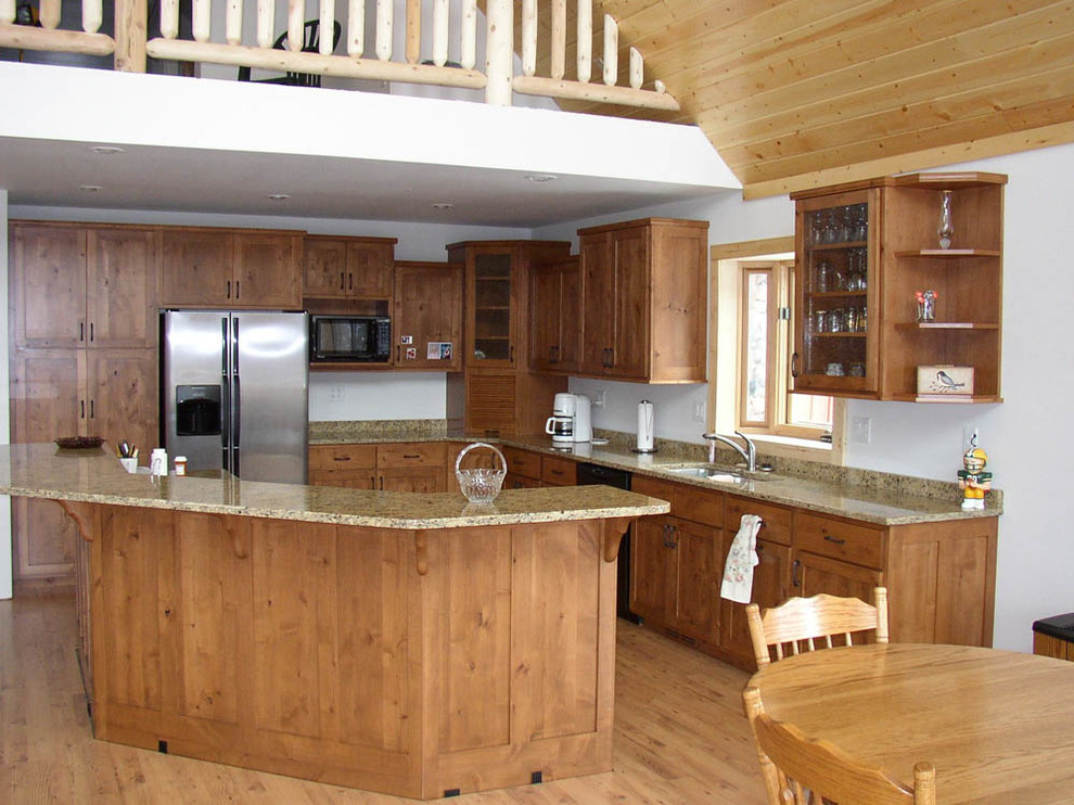 Open concept kitchen - large rustic l-shaped light wood floor and brown floor open concept kitchen idea with shaker cabinets, medium tone wood cabinets, stainless steel appliances, an island, an undermount sink and granite countertops