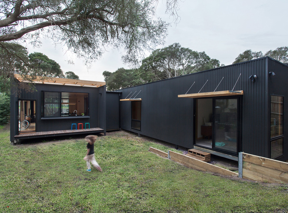 This is an example of a mid-sized contemporary grey exterior in Melbourne with metal siding and a flat roof.