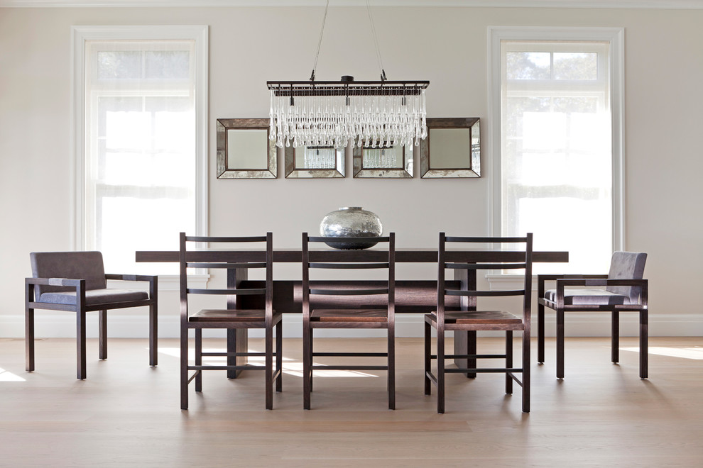 This is an example of a contemporary dining room in New York with beige walls and light hardwood floors.