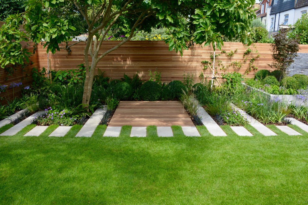 Inspiration for a mid-sized contemporary backyard full sun garden for summer in London with with pond and natural stone pavers.